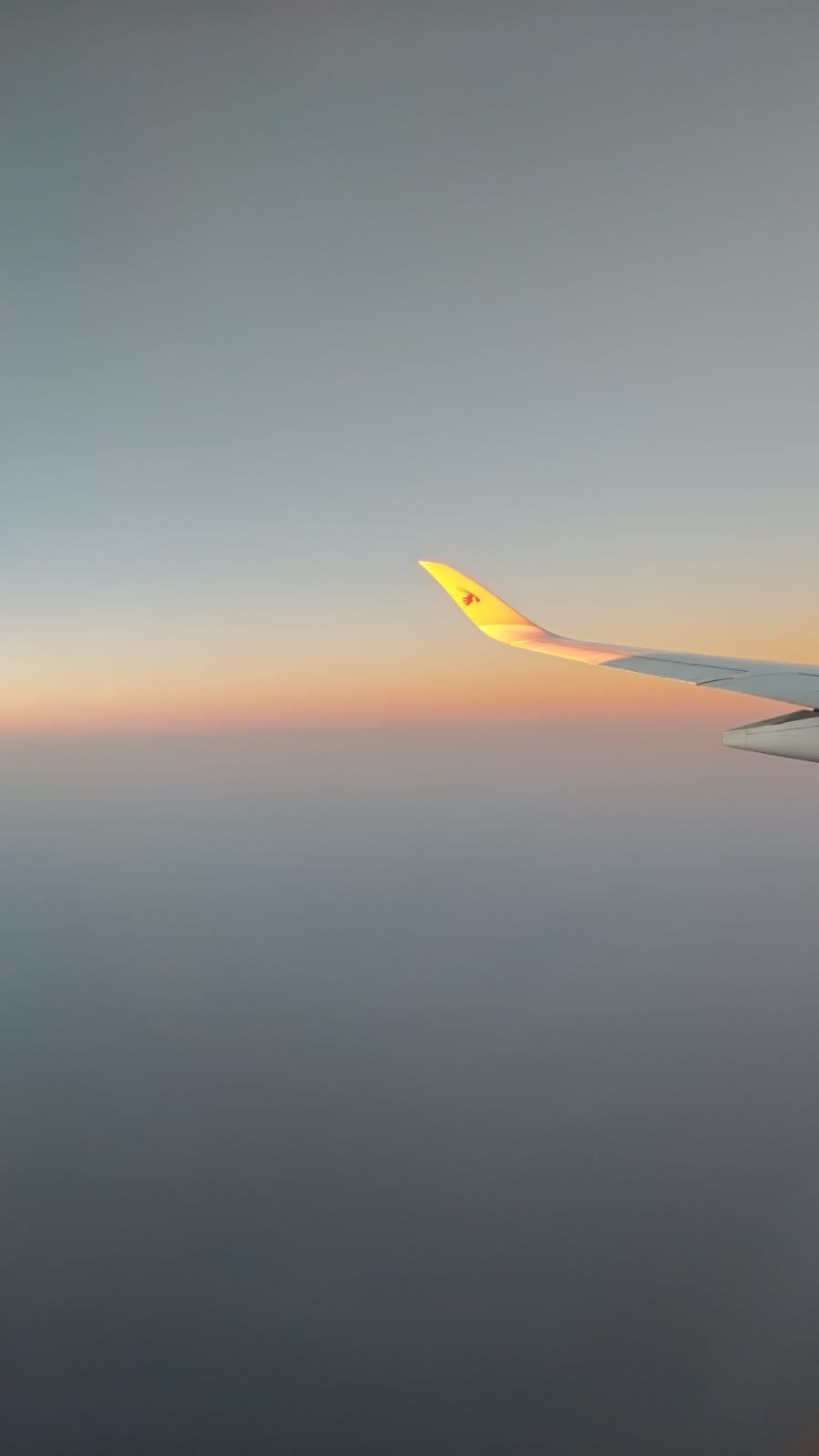 Aile d'avion au coucher du soleil, vue par le hublot